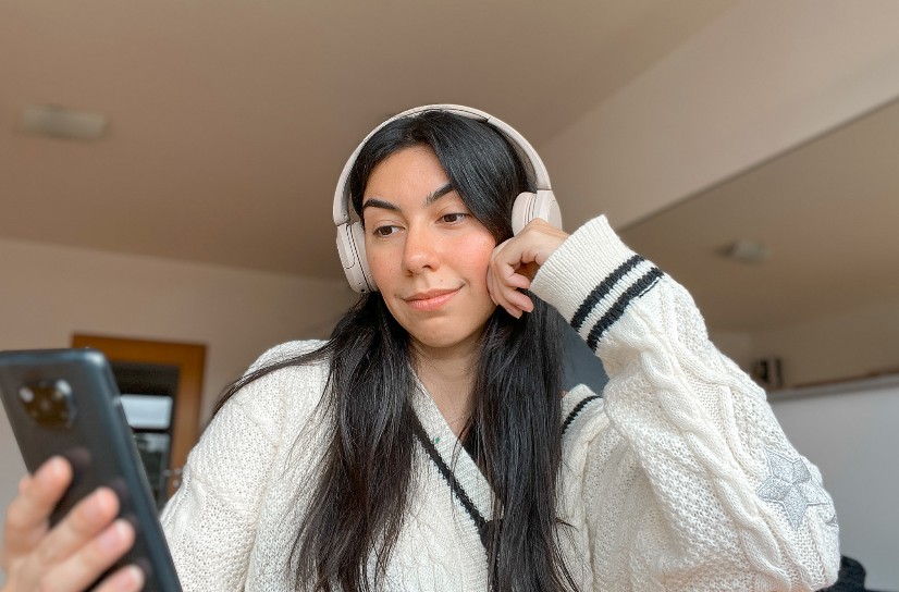 Creator with headphones checking phone