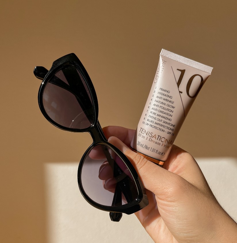Holding sunglasses and sunscreen